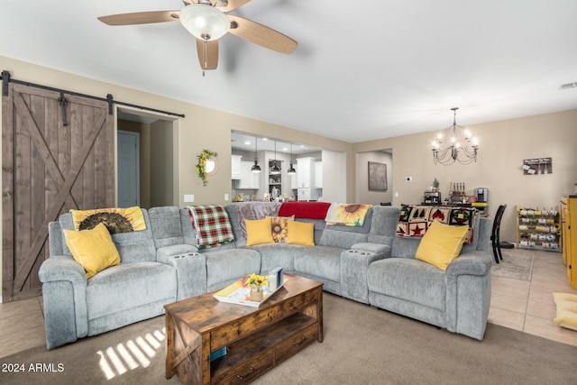 carpeted living room with a barn door and ceiling fan with notable chandelier