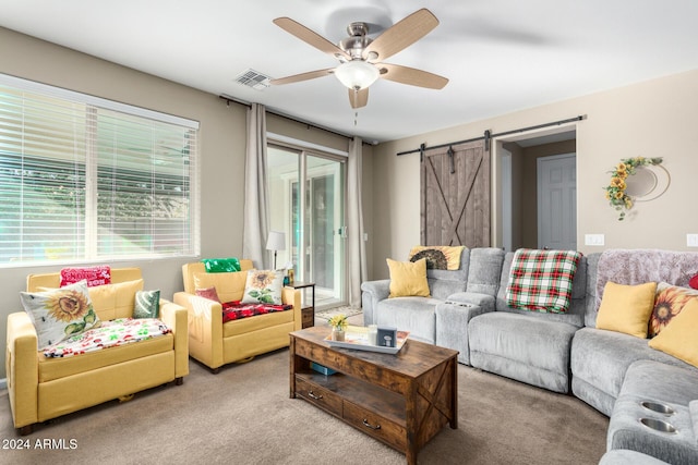 living room with light carpet, a barn door, a wealth of natural light, and ceiling fan