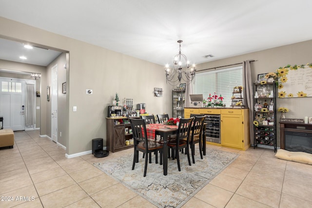 dining area with a notable chandelier, light tile patterned floors, and wine cooler