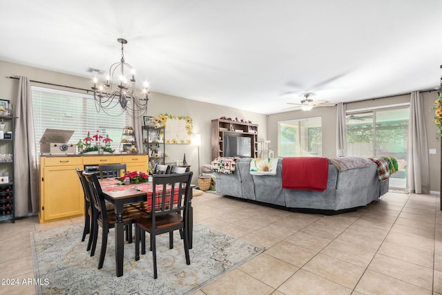 dining area with light tile patterned floors and ceiling fan with notable chandelier