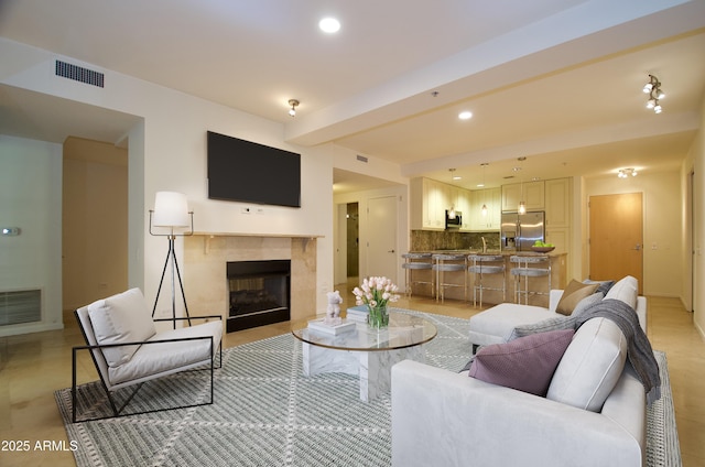 living room with beam ceiling and a tile fireplace