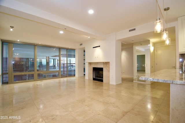 unfurnished living room featuring a tile fireplace and floor to ceiling windows