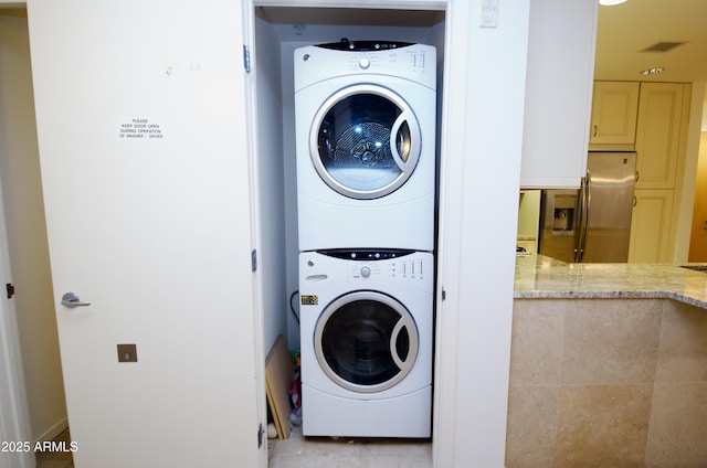 washroom featuring stacked washing maching and dryer