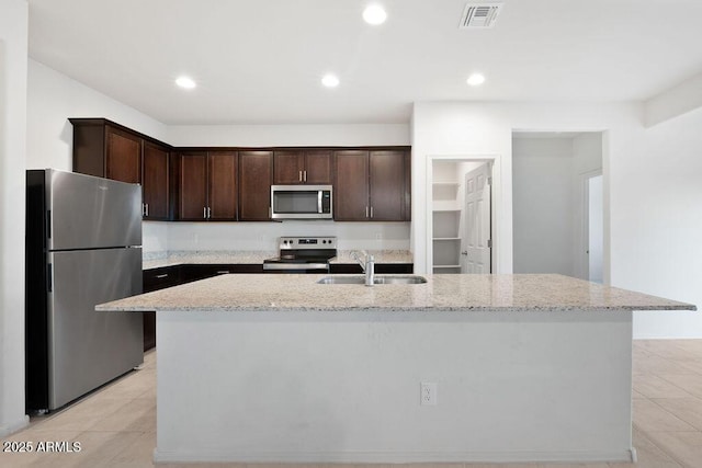 43637 W Cypress Ln, Maricopa, AZ 85138 - kitchen with stainless steel appliances, a sink, light stone counters, visible vents, and dark brown cabinets