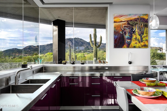 kitchen with stainless steel counters, a mountain view, and a wealth of natural light