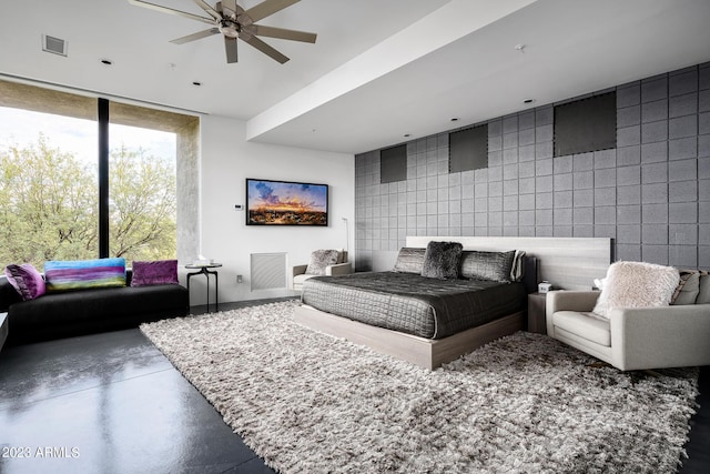 bedroom featuring concrete floors, expansive windows, ceiling fan, and tile walls