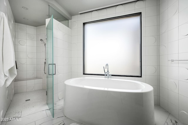 bathroom featuring independent shower and bath and tile walls