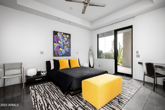 bedroom featuring access to outside, ceiling fan, and a tray ceiling