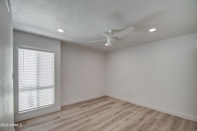 spare room featuring a textured ceiling, light hardwood / wood-style floors, and ceiling fan