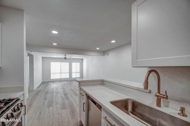 kitchen with light hardwood / wood-style floors, sink, white cabinetry, stainless steel appliances, and ceiling fan