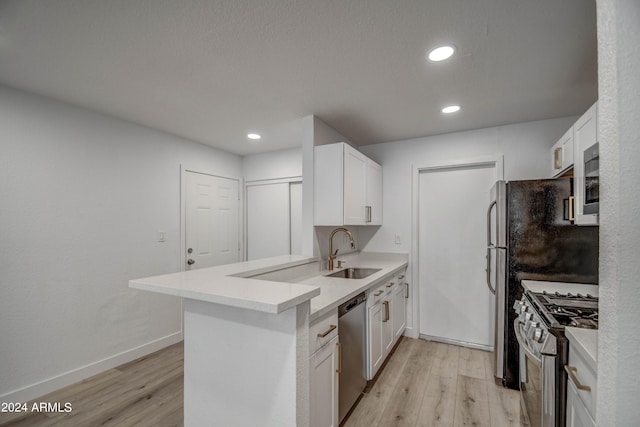 kitchen featuring appliances with stainless steel finishes, white cabinetry, and sink