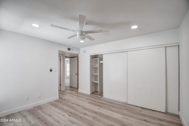 unfurnished bedroom featuring light hardwood / wood-style floors, ceiling fan, and a closet