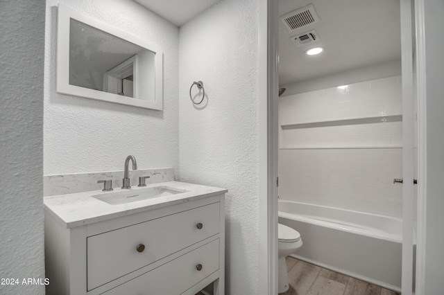 full bathroom with shower / tub combination, vanity, toilet, and hardwood / wood-style flooring