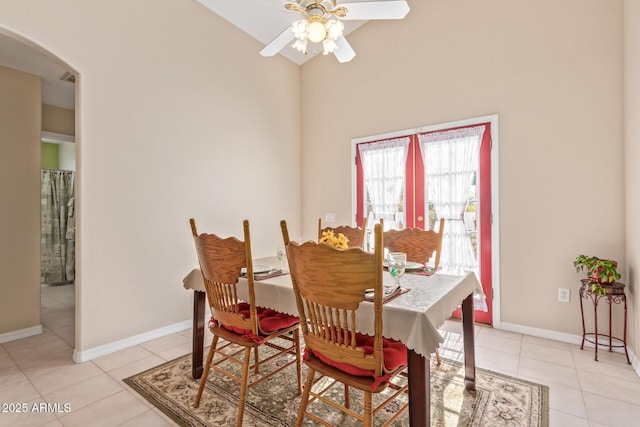 tiled dining area featuring ceiling fan and lofted ceiling