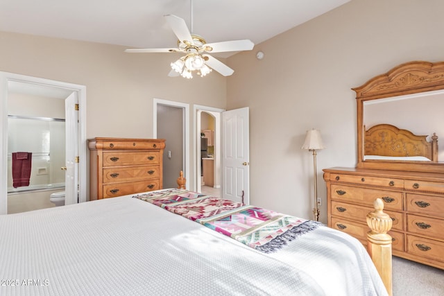 bedroom with lofted ceiling, connected bathroom, light colored carpet, and ceiling fan