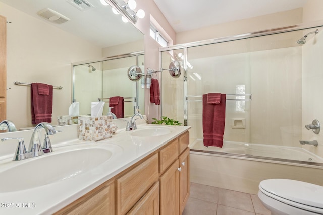 full bathroom featuring toilet, vanity, shower / bath combination with glass door, and tile patterned flooring