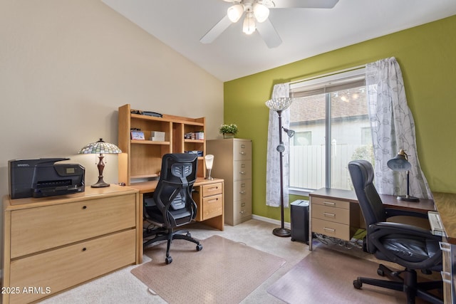 office space featuring vaulted ceiling, light carpet, and ceiling fan