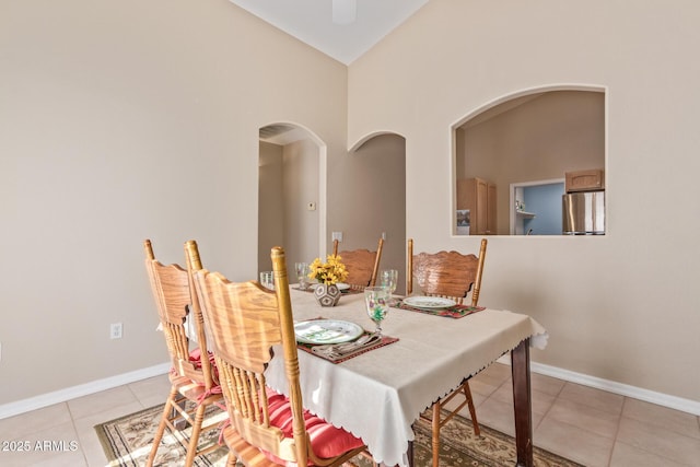 dining room with high vaulted ceiling and light tile patterned floors