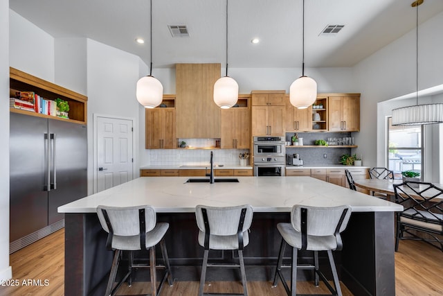 kitchen featuring visible vents, a sink, stainless steel appliances, and open shelves