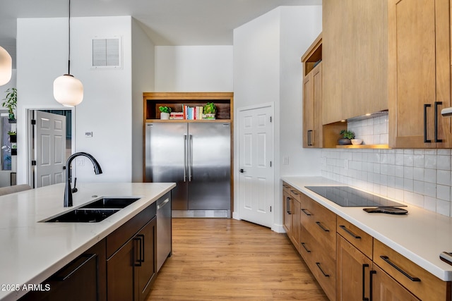 kitchen with visible vents, open shelves, light wood-style floors, stainless steel appliances, and a sink