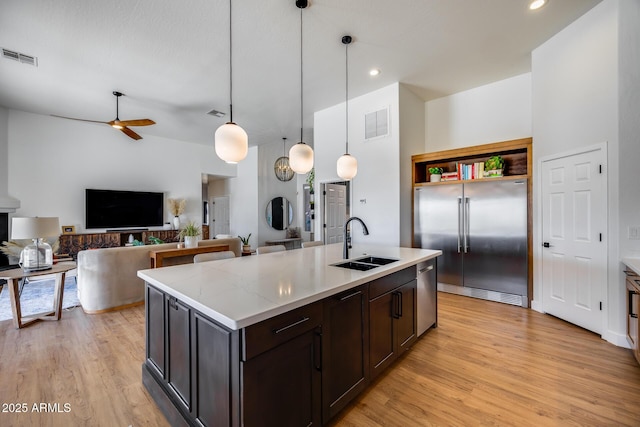 kitchen featuring a sink, stainless steel appliances, visible vents, and light wood finished floors