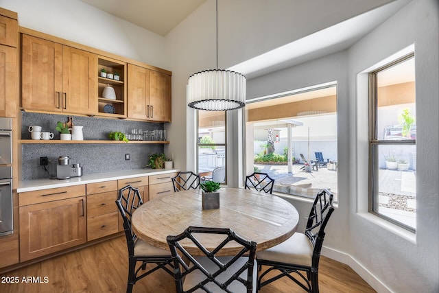 dining area with baseboards, light wood-style floors, and a healthy amount of sunlight