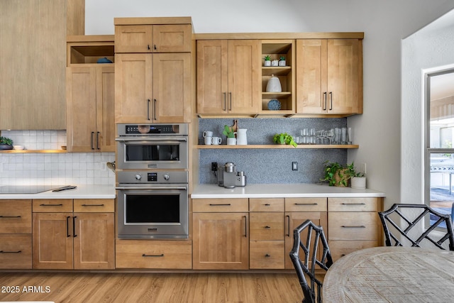 kitchen with open shelves, stainless steel double oven, and light countertops