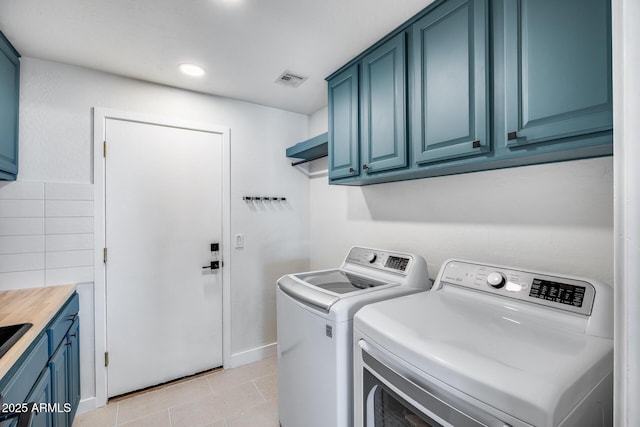 laundry room featuring cabinet space, visible vents, washing machine and dryer, and light tile patterned flooring