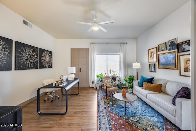 living area featuring a ceiling fan, wood finished floors, and visible vents