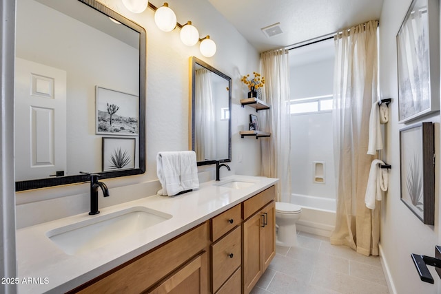 bathroom featuring a sink, visible vents, double vanity, and tile patterned floors