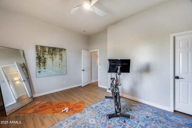 workout area with baseboards, wood finished floors, and ceiling fan