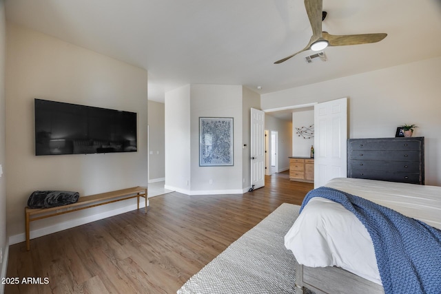 bedroom with a ceiling fan, wood finished floors, visible vents, and baseboards