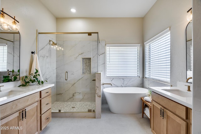 bathroom featuring a soaking tub, two vanities, a marble finish shower, and a sink