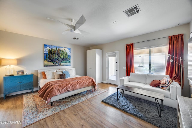 bedroom with access to exterior, visible vents, and wood finished floors