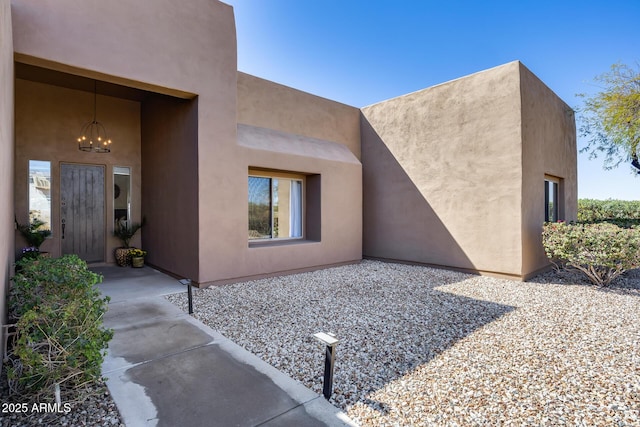 view of exterior entry featuring a patio area and stucco siding