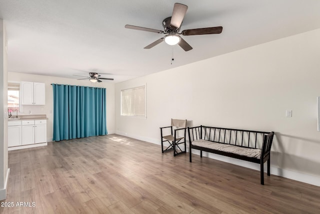 7702 W Piute Ave, Glendale, AZ 85308 - living area featuring ceiling fan, light wood-style floors, baseboards, and plenty of natural light