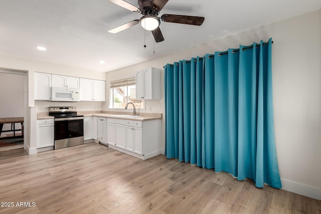 7702 W Piute Ave, Glendale, AZ 85308 - kitchen featuring stainless steel electric range, white microwave, a sink, dishwashing machine, and white cabinetry