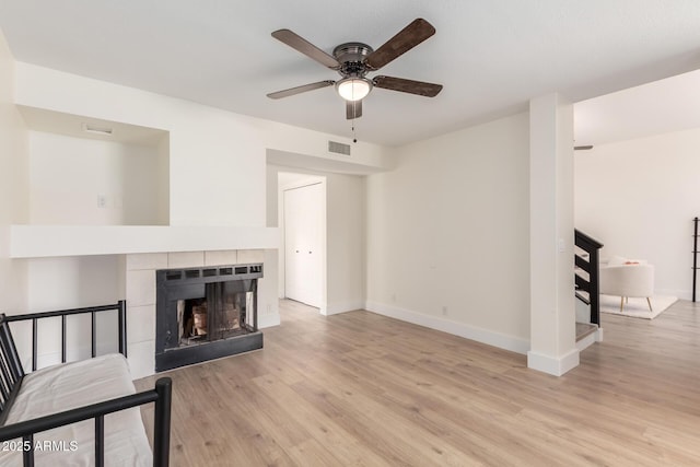 7702 W Piute Ave, Glendale, AZ 85308 - unfurnished living room with ceiling fan, light wood-type flooring, baseboards, and a tile fireplace