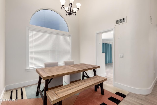 7702 W Piute Ave, Glendale, AZ 85308 - dining room featuring a chandelier, baseboards, light wood-style floors, and a towering ceiling