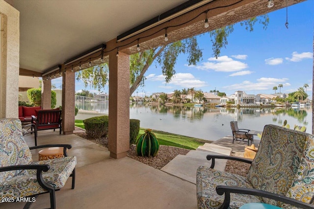 view of patio featuring a water view and fence