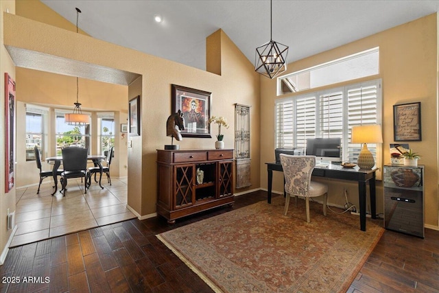 office featuring high vaulted ceiling, a notable chandelier, baseboards, and hardwood / wood-style flooring