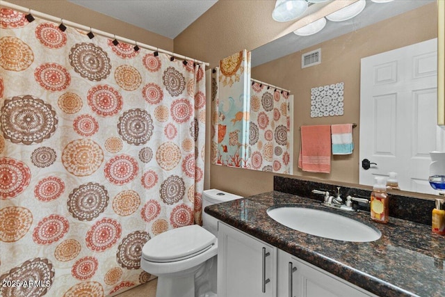 bathroom featuring visible vents, vanity, and toilet