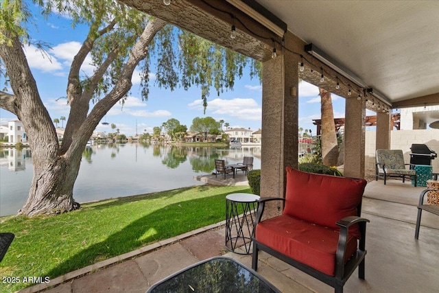 view of patio / terrace featuring area for grilling, a water view, and fence