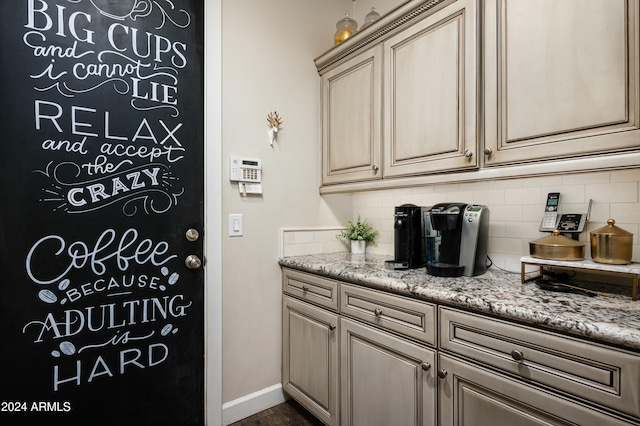 interior space featuring light stone countertops and tasteful backsplash