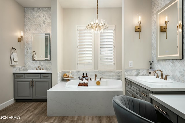 bathroom with a washtub, vanity, hardwood / wood-style flooring, and an inviting chandelier