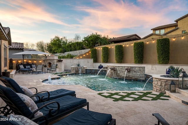 pool at dusk with pool water feature, an outdoor living space, and a patio