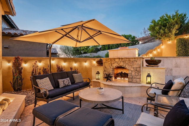 patio terrace at dusk featuring an outdoor living space with a fireplace