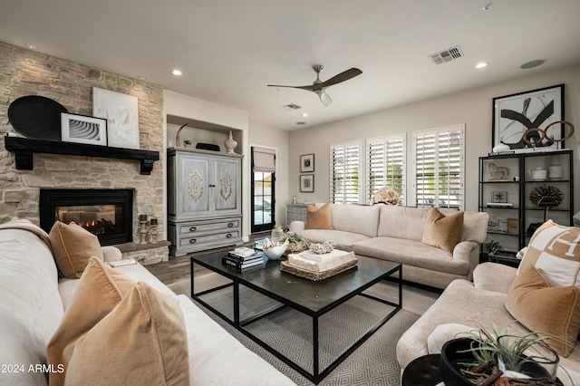 living room featuring ceiling fan, wood-type flooring, and a fireplace