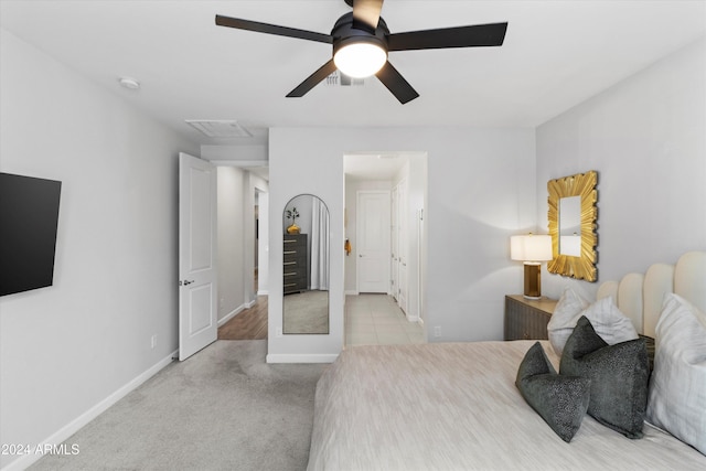 bedroom with ceiling fan and light carpet