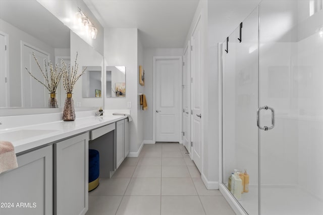 bathroom featuring tile patterned flooring, vanity, and a shower with door